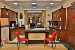 a kitchen with red chairs and a table and cabinets at Artemis Hotel in Cefalù