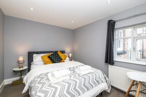チェスターにあるThe POPULAR Chester Racecourse Apartments, Sleeps 4, FREE Parkingの大きなベッドと窓のある寝室