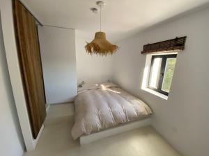 een bed in een witte kamer met een raam bij Casa Limon in Pinos del Valle