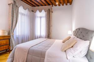 una camera con un letto bianco e una finestra di Ca' del Doge San Marco a Venezia