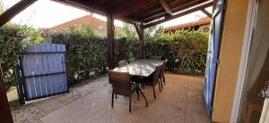 a table and chairs sitting on a patio at LES MARINES 2 - Villa en résidence avec piscine à 2 pas de la plage - Clim - parking in Saint-Cyprien