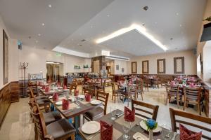 a restaurant with tables and chairs in a room at Orchid Hotel Al Barsha "Formerly Golden Tulip Hotel Al Barsha" in Dubai