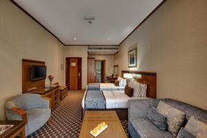 a hotel room with a bed and a couch at Orchid Hotel Al Barsha "Formerly Golden Tulip Hotel Al Barsha" in Dubai