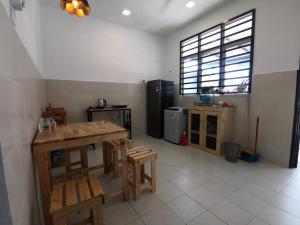 een keuken met een tafel en stoelen in een kamer bij MODERN , SPACIOUS GAMBANG UMP 18 Guest House in Gambang