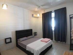 um quarto com uma cama e uma janela com cortinas azuis em MODERN , SPACIOUS GAMBANG UMP 18 Guest House em Gambang