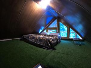 ein Schlafzimmer mit einem Bett in einem Zimmer mit einem Fenster in der Unterkunft Reverberate Cafe & Cottages - Negi's Place in Jibhi