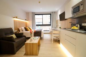 a kitchen and living room with a couch and a table at Studios Cielo Madrid in Madrid