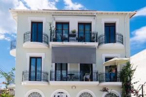 un edificio blanco con balcones y mesas. en LefkasLoft, en Lefkada