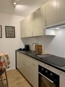 a kitchen with white cabinets and a sink and a stove at Katowice City Centre II in Katowice