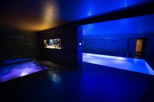a dark room with a pool and a aquarium at Hotel Kras in Jedovnice