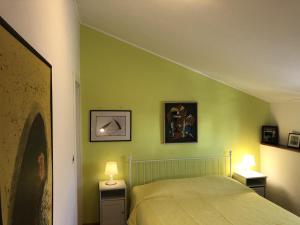 a bedroom with green walls and a bed with two lamps at Family Rooms Sabrina in Poreč