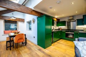 a kitchen with green cabinets and a wooden floor at 3 Clementhorpe Maltings in York
