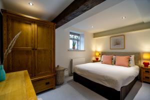 a bedroom with a large bed and a wooden cabinet at 3 Clementhorpe Maltings in York