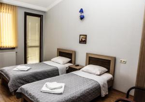 a hotel room with two beds with towels on them at Tbilisi Tower Apartment in Tbilisi City