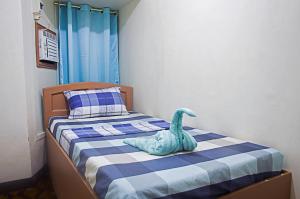 a bedroom with a bed with a stuffed dinosaur on it at Providence Travellers Inn & Spa in Tagbilaran City