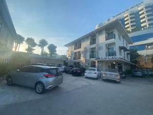 a parking lot with cars parked in front of a building at Kangaroo Residence Udonthani in Udon Thani