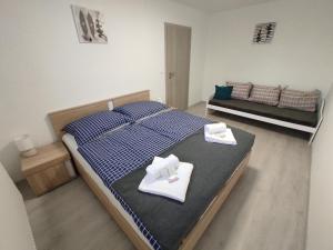a bedroom with a bed with two white towels on it at APARTMÁNY BYTČA in Bytča