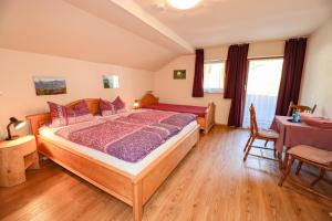 a bedroom with a bed and a table and chairs at Landhaus Freund in Berchtesgaden