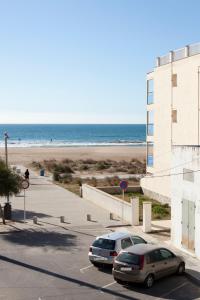 dos coches estacionados en un estacionamiento junto a la playa en Beach Castelldefels en Castelldefels