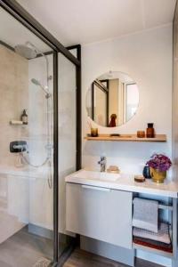 uma casa de banho com um chuveiro, um lavatório e um espelho. em Camping Les Bois Flottés em Salin-de-Giraud