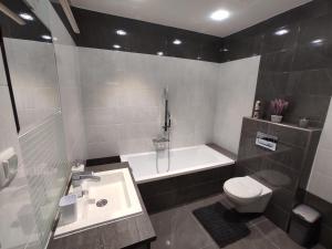 a bathroom with a sink and a toilet and a tub at APARTMÁNY BYTČA in Bytča