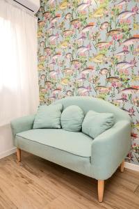 ein Sofa im Wohnzimmer mit Blumentapete in der Unterkunft PRESTIGE BOUTIQUE HOMES - Duomo 2 in Mailand