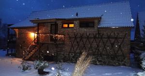 a brick house with a deck in the snow at Ferienhof Löschebrand in Bad Saarow