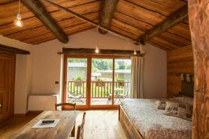 sypialnia z łóżkiem i drewnianym stołem w obiekcie L'Escola e Lou Mulin w mieście Sampeyre