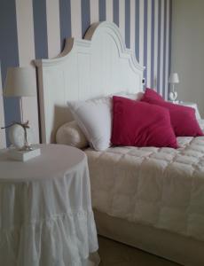 una camera da letto con un letto con cuscini viola e bianchi di Agriturismo Fioredizucca ad Albenga