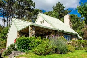 una casa de piedra con techo verde en Houtkapperspoort Mountain Cottages en Ciudad del Cabo