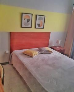 a bedroom with a large bed with two pictures on the wall at Mix 2 in Mindelo