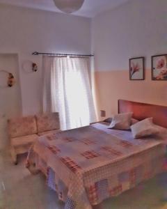 um quarto com uma cama, um sofá e uma janela em Mix 2 em Mindelo