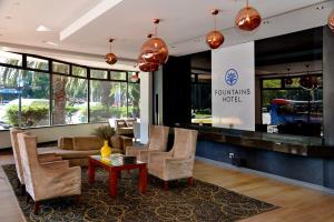 开普敦Fountains Hotel的酒店大堂里摆放着椅子和桌子