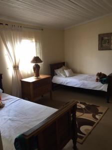 a bedroom with two beds and a lamp on a table at Bloekomhuis in Smithfield