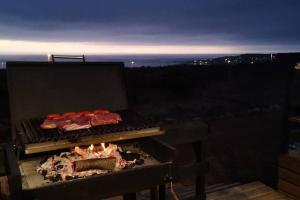 twee stukken vlees koken op een grill 's nachts bij Cómoda Casa en la Playa in Guaquen