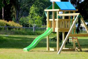 a playground with a green slide in a park at Brīvdienu māja Sauleskrasti in Mērsrags
