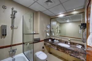 a bathroom with a sink and a shower and a toilet at Orchid Hotel Al Barsha "Formerly Golden Tulip Hotel Al Barsha" in Dubai