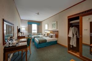 a hotel room with a bed and a desk at Orchid Hotel Al Barsha "Formerly Golden Tulip Hotel Al Barsha" in Dubai