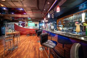a bar with a bunch of stools in a room at Orchid Hotel Al Barsha "Formerly Golden Tulip Hotel Al Barsha" in Dubai