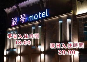 a motel sign on the side of a building with neon signs at 浪琴Motel文創旅館 in Taichung