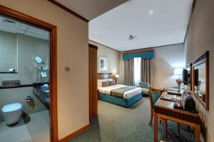 a hotel room with a bed and a bathroom at Orchid Hotel Al Barsha "Formerly Golden Tulip Hotel Al Barsha" in Dubai