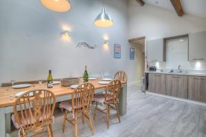 a kitchen with a wooden table with chairs and a counter at Preswylfa in Abersoch