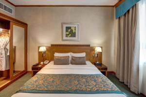 a hotel room with a large bed and two tables at Orchid Hotel Al Barsha "Formerly Golden Tulip Hotel Al Barsha" in Dubai