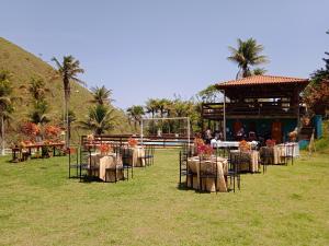 a group of tables and chairs in front of a building at Fazenda Lagoa Azul in Silva Jardim