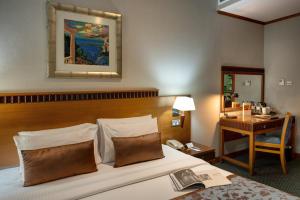 a hotel room with a bed and a desk at Orchid Hotel Al Barsha "Formerly Golden Tulip Hotel Al Barsha" in Dubai