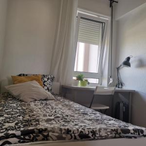 1 dormitorio con cama, ventana y escritorio en Forts en Lisboa