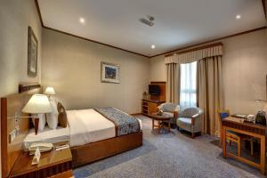 a hotel room with a bed and a desk at Orchid Hotel Al Barsha "Formerly Golden Tulip Hotel Al Barsha" in Dubai