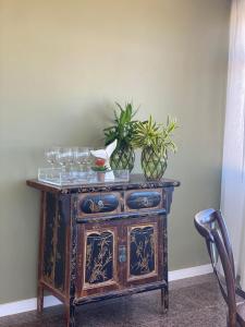 a wooden cabinet with glasses and potted plants on it at Janelas de Sol 400 in Fortaleza