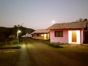 a house on the side of a street at night at Pousada Malacara in Praia Grande