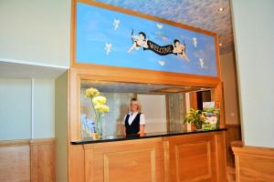 a woman standing in front of a mirror with a picture of a dog at Four Saints Brig Y Don Hotel in Llandudno